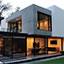 Contemporary house exterior with lit windows at dusk