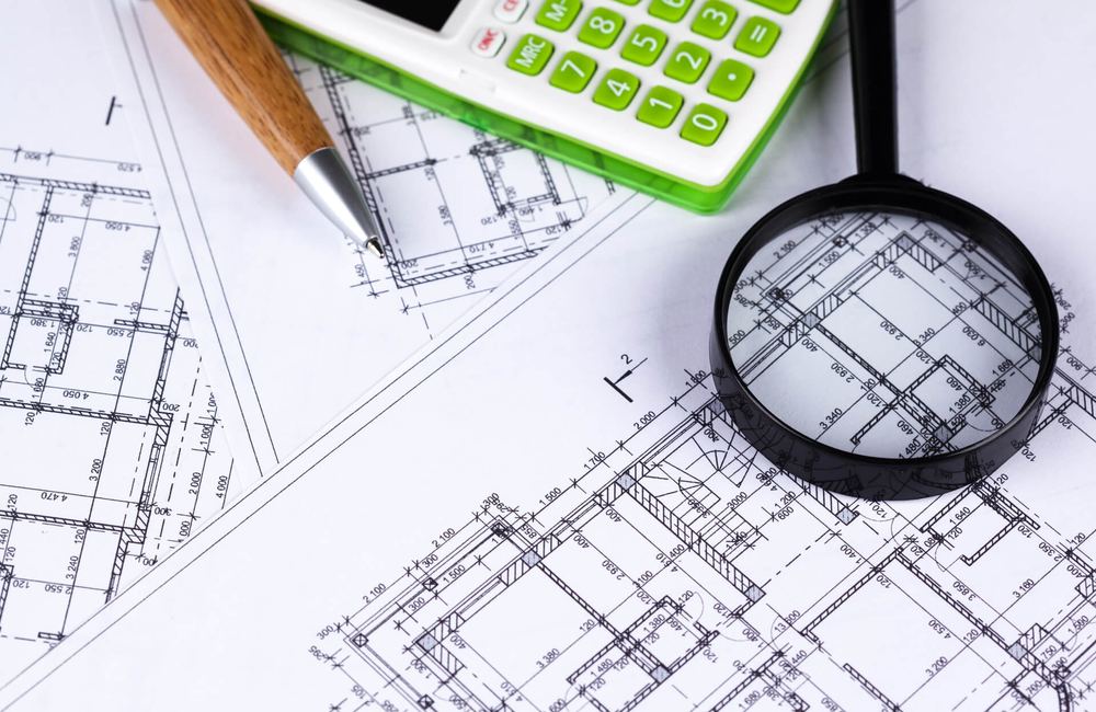Magnifying glass over construction drawings during a specification review